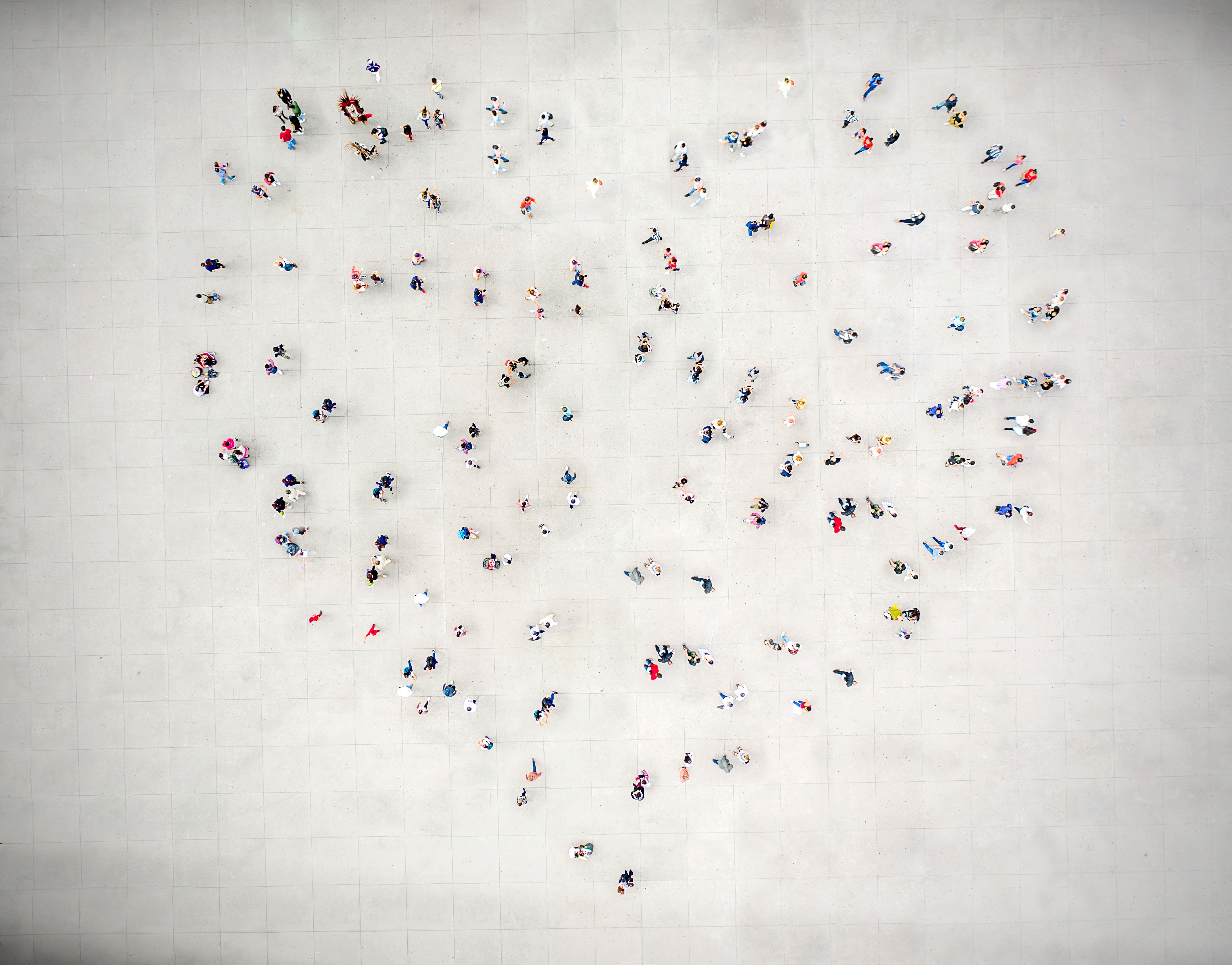 A group of people standing together in the collective shape of a heart.