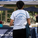 woman standing with back to camera in front of UC Davis promo table