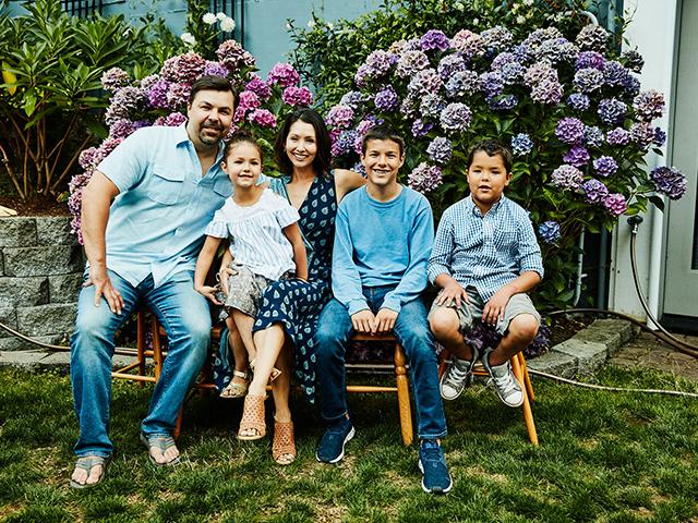 family of five posing in chairs on grass